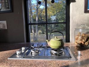 a tea kettle sitting on top of a stove at Porcupine House in Magaliesburg