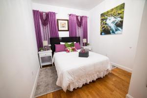 Schlafzimmer mit einem Bett mit rosa und grünen Kissen in der Unterkunft Top Floor with Skylight Brooklyn in Brooklyn