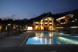 a swimming pool in front of a building at night at Ashoka Resort Pvt. Ltd in Chitwan