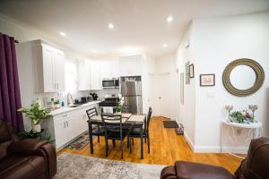 a kitchen with white cabinets and a table and chairs at Top Floor with Skylight Brooklyn in Brooklyn