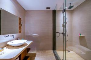 a bathroom with a sink and a shower at VOUK Hotel and Suites Nusa Dua Bali in Nusa Dua