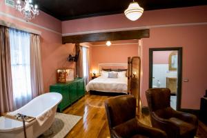 1 dormitorio y baño con cama y bañera. en Hotel Australasia en Eden