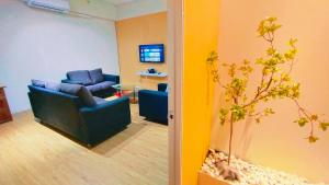 a living room with a blue couch and a tv at Kulai Bandar Putra Self Service Hotel near IOI Mall in Kulai