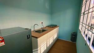 a kitchen with a sink and a refrigerator at Kulai Bandar Putra Self Service Hotel near IOI Mall in Kulai