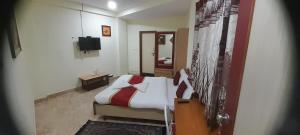 a bedroom with a bed and a television in it at CTC GARDENIA RESIDENCY in Bangalore