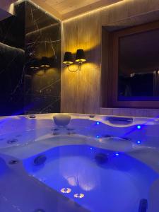 a large tub in a bathroom with blue lights at Little House in Ząb +17 photos