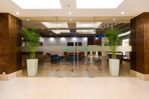 um hall de entrada com dois vasos de plantas num edifício em Lemon Tree Hotel Whitefield, Bengaluru em Bangalore