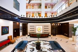 un vestíbulo de un hotel con mesa y sillas en Lemon Tree Hotel Whitefield, Bengaluru, en Bangalore