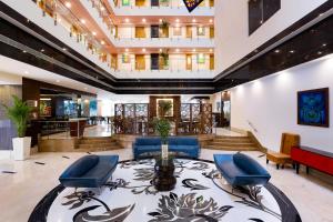 a lobby with blue chairs and a table at Lemon Tree Hotel Whitefield, Bengaluru in Bangalore