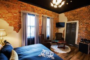 ein Schlafzimmer mit einem Bett und einer Ziegelwand in der Unterkunft Hotel Australasia in Eden