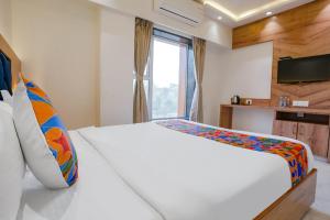 1 dormitorio con 1 cama blanca grande y ventana en FabHotel Pancharatna Regency en Pune