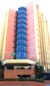 um edifício alto com janelas azuis em frente em FLAT ECONÔMICO E ACONCHEGANTE, 1Qt, sala e cozinha, Centro-GO em Goiânia