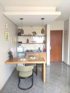 a kitchen with a wooden table and two chairs at FLAT ECONÔMICO E ACONCHEGANTE, 1Qt, sala e cozinha, Centro-GO in Goiânia