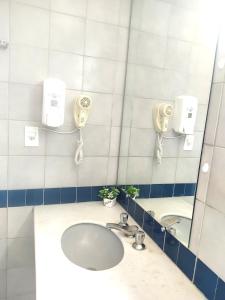 a bathroom with a sink and a mirror at FLAT ECONÔMICO E ACONCHEGANTE, 1Qt, sala e cozinha, Centro-GO in Goiânia