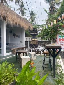 a patio with tables and chairs in front of a building at PACA'S Reggae Bar & Hostel in Ambat