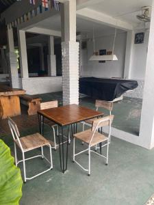 a wooden table and chairs in a room with a boat at PACA'S Reggae Bar & Hostel in Ambat