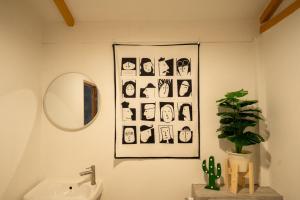 La salle de bains est pourvue d'un lavabo, d'un miroir et d'une photo. dans l'établissement Tararom ธาราลม, 