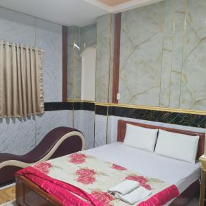 a bedroom with a bed with red and white sheets at HONG CUC Hotel in Ho Chi Minh City