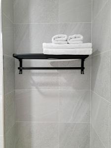 a bathroom with three towels on a shelf at 如日民宿 in Taitung City +23 photos
