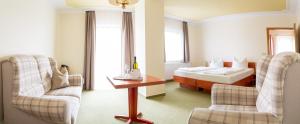 ein Hotelzimmer mit einem Bett, einem Tisch und Stühlen in der Unterkunft Landhotel Biberburg in Bad Liebenwerda