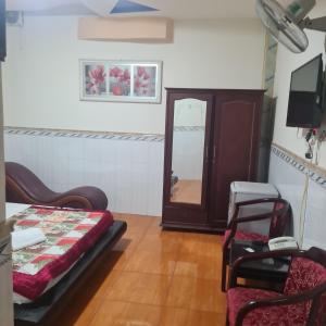 a room with a mirror and a bed and a chair at HONG CUC Hotel in Ho Chi Minh City