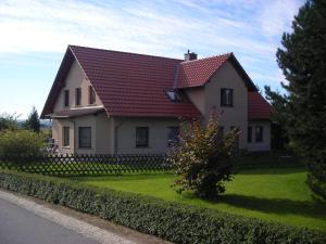 シュトルペンにあるFerienwohnung Gisela Kästner Stolpenの緑の庭に赤屋根の家