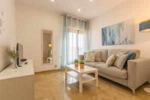 uma sala de estar com um sofá e uma mesa em Osario Suite Centro Cordoba em Córdoba