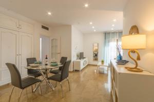 a dining room and living room with a table and chairs at Osario Suite Centro Cordoba in Córdoba