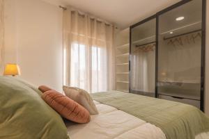a bedroom with a bed with pillows and a window at Osario Suite Centro Cordoba in Córdoba