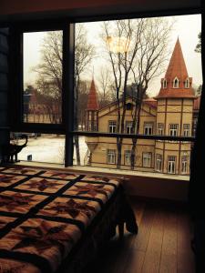een slaapkamer met een groot raam met uitzicht op een gebouw bij Apartment in Druskininkai Lithuania in Druskininkai