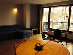 a living room with a table with a bowl of fruit on it at Apartment in Druskininkai Lithuania in Druskininkai