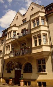 ein großes weißes Gebäude mit Fenstern und einem Balkon in der Unterkunft Hotel Minerva in Freiburg im Breisgau