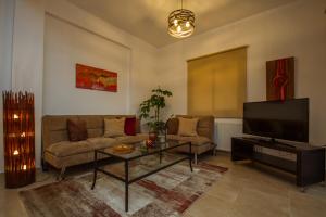 een woonkamer met een bank en een flatscreen-tv bij Villa Callisto by AgroHolidays in Kyperounda