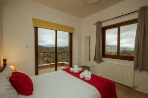 a bedroom with a large bed and a large window at Villa Callisto by AgroHolidays in Kyperounda