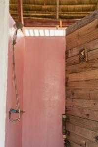 a shower in a bathroom with a pink wall at Young Wild and Free in Koh Kong
