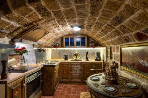 a kitchen with a stone ceiling and a table at Mythic Spa Villa in Rhodes Town