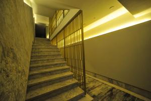 una escalera en un edificio con suelo de madera y barandilla en The Alpfine Hotel, en Ankara