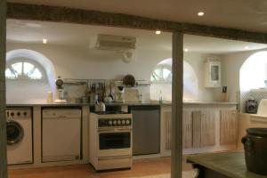 a large kitchen with a stove and a sink at Villa Pradias in Loures-Barousse