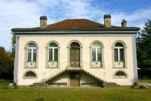 a large white house with a staircase in front of it at Villa Pradias in Loures-Barousse