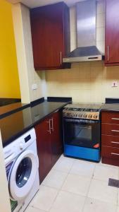 y cocina con fogones y lavadora. en Stufio flat DG085, Close to The Gardens Metro 6 min walkable, en Dubái