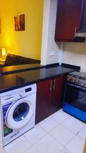 cocina con lavadora y fogones en Stufio flat DG085, Close to The Gardens Metro 6 min walkable, en Dubái