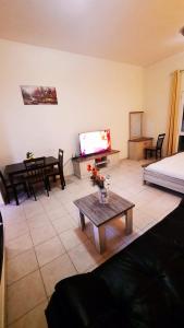 sala de estar con cama, TV y mesa en Stufio flat DG085, Close to The Gardens Metro 6 min walkable, en Dubái