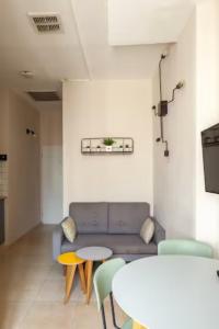 a living room with a couch and a table and chairs at OurPlace Nachalat Binyamin in Tel Aviv