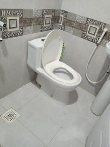 La salle de bains est pourvue de toilettes blanches. dans l'établissement Pearl Cottage Airport, à Karachi