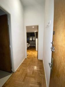 um corredor que leva a uma sala de estar com piso de madeira em Downtown Apartament Retiro em Buenos Aires
