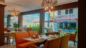 a restaurant with tables and chairs and a large window at C & N Hotel - SHA Extra Plus in Patong Beach