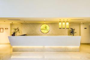 a lobby with a large white reception desk at Lemon Tree Hotel Electronics City in Bangalore