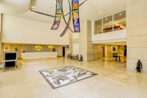 un gran vestíbulo con una alfombra en el suelo y vidrieras en Lemon Tree Hotel Electronics City, en Bangalore