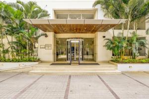 班加羅爾的住宿－電子城檸檬樹酒店，棕榈树建筑的开放式门