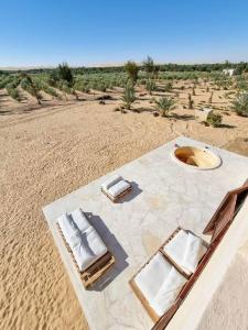 an aerial view of a table and chairs in the desert at A Home with a Dome in ‘Izbat Ţanāţī